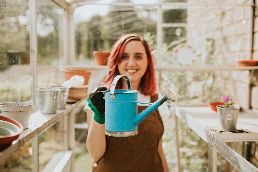 Female gardener with a blue watering can