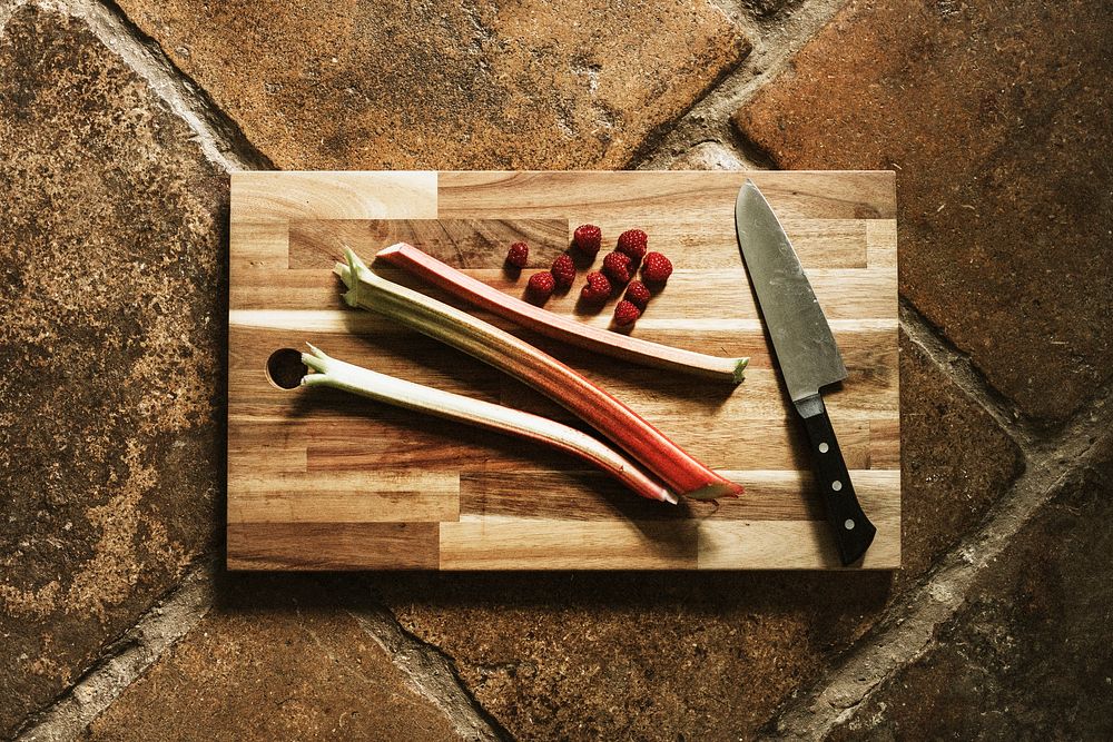 Fresh vegetable and raspberry on a wooden cut board flatlay