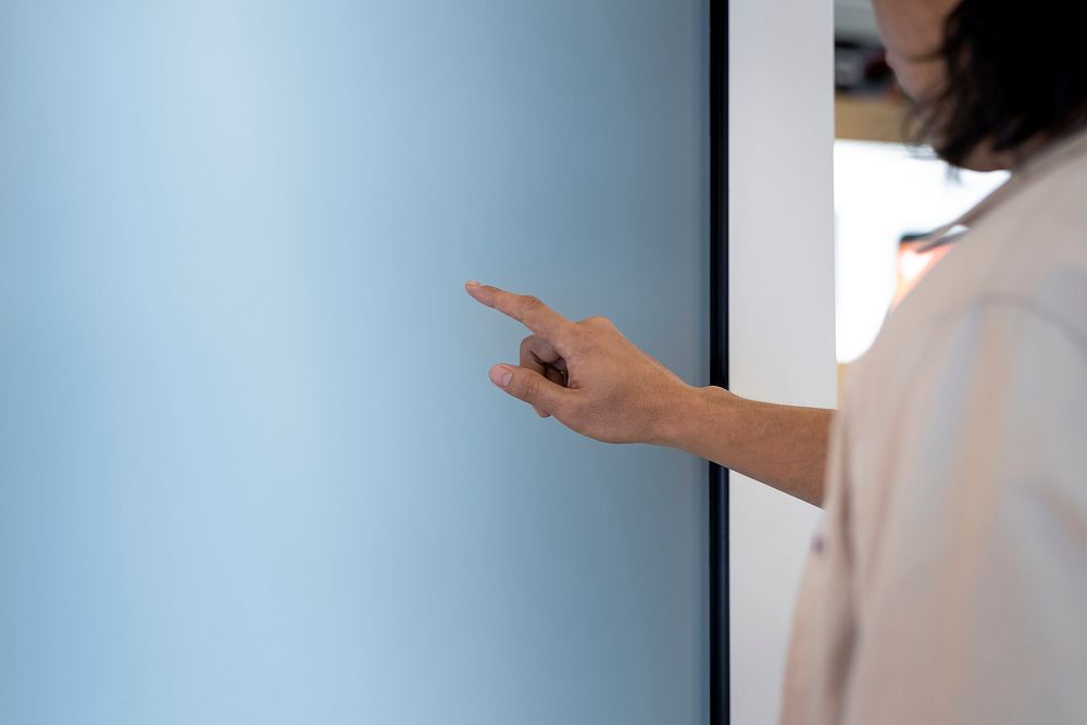 Man touching a large white digital screen