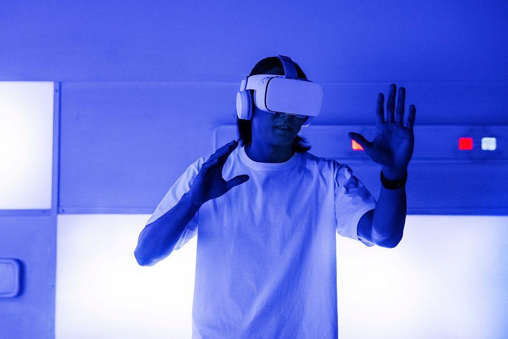 Asian man with VR headset touching a virtual screen