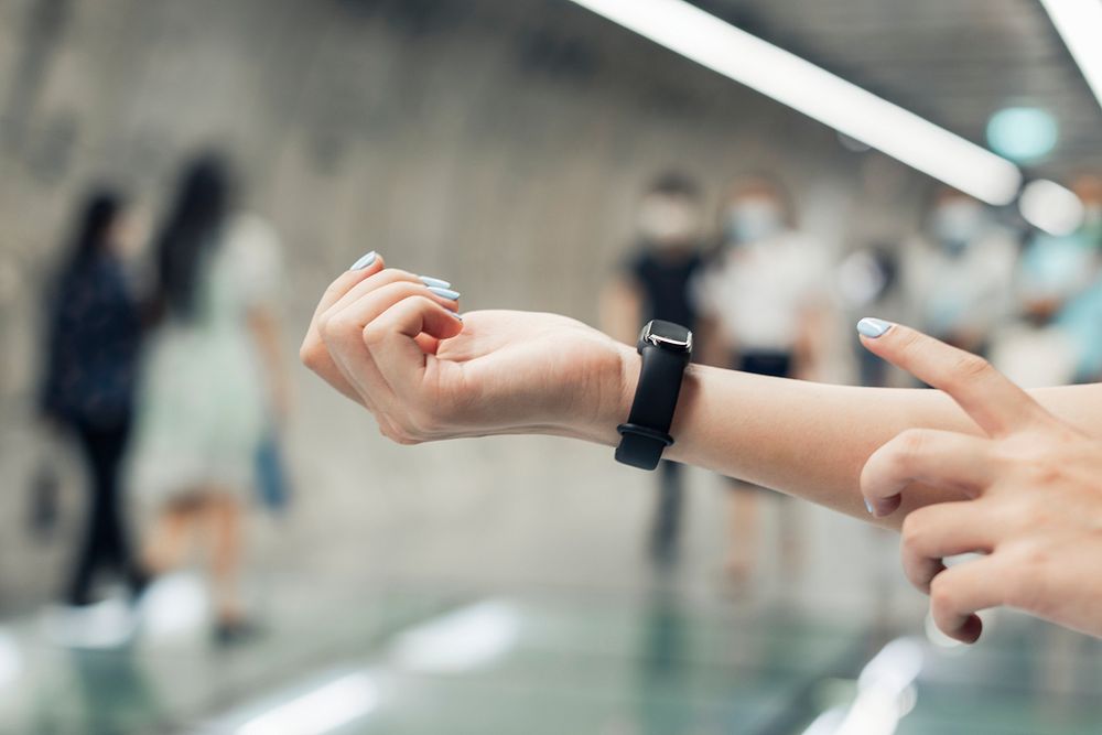 Girl wearing a fitness tracker and checking heart rate on wrist