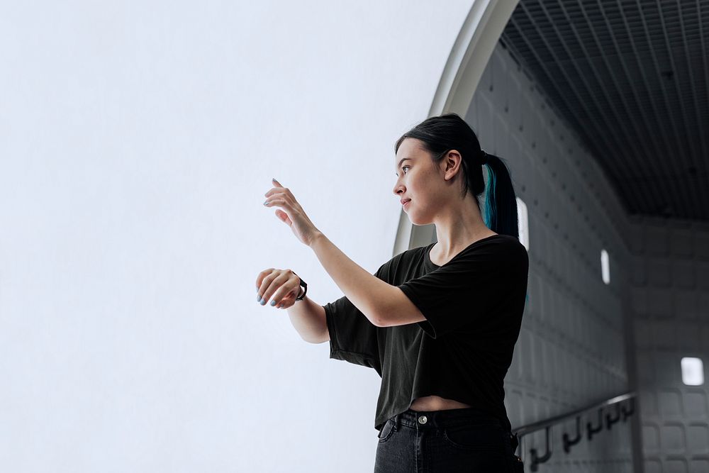 Girl using smartwatch to connect to a large interactive screen