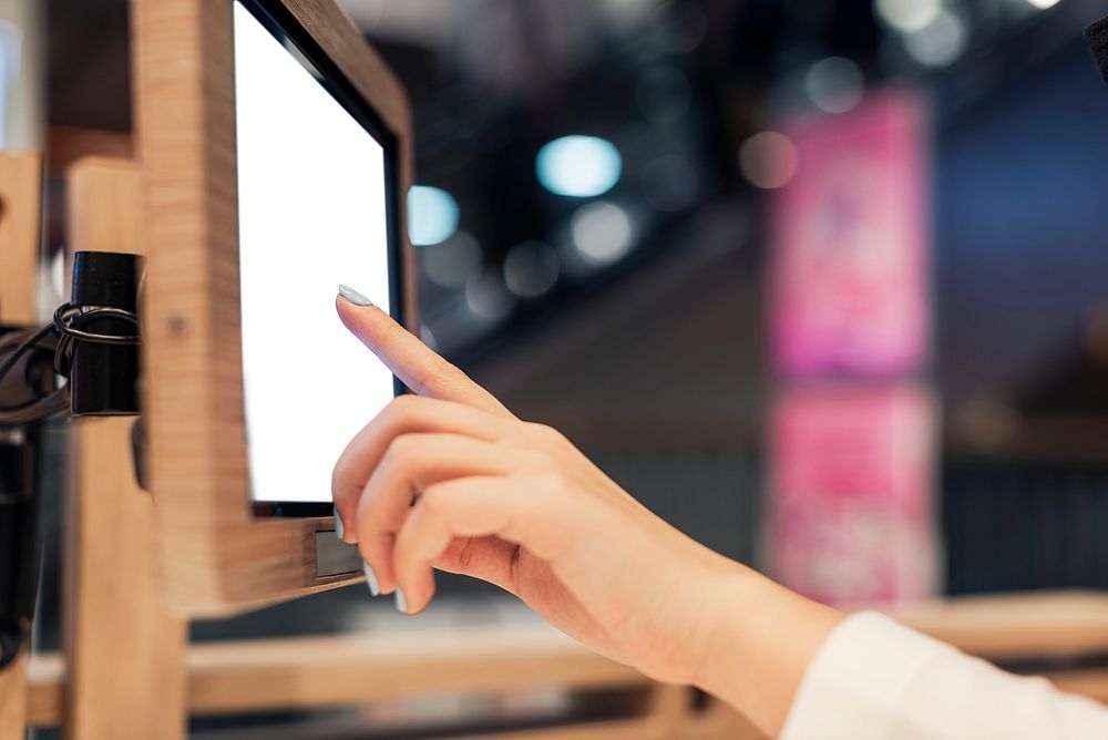 Girl selecting items to buy from a screen in a shop