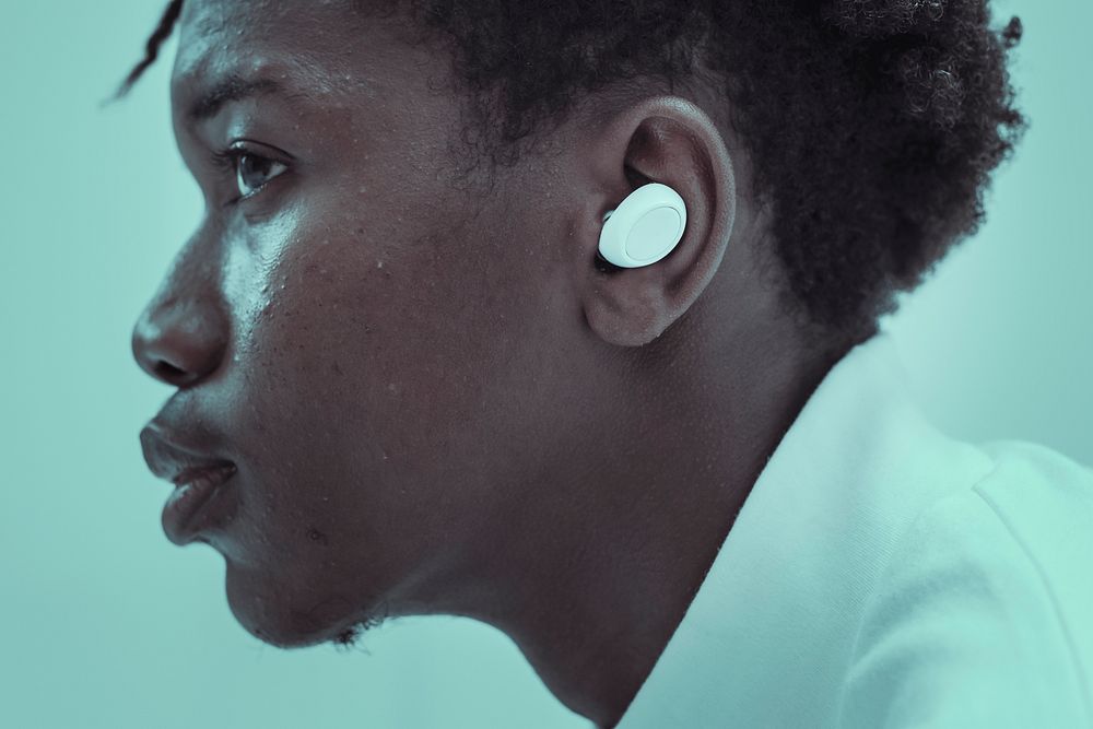 African American man listening to music through wireless earbuds