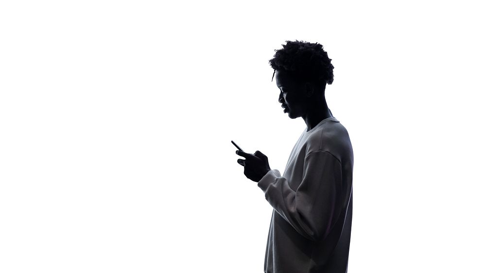 Silhouette of a man using a smartphone
