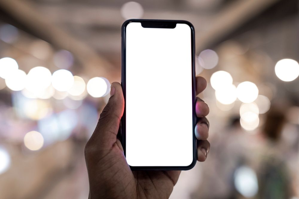 Guy holding a blank smartphone screen while walking in the city