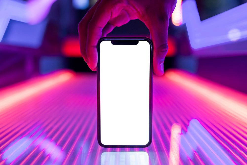 Smartphone screen on glowing neon lights table