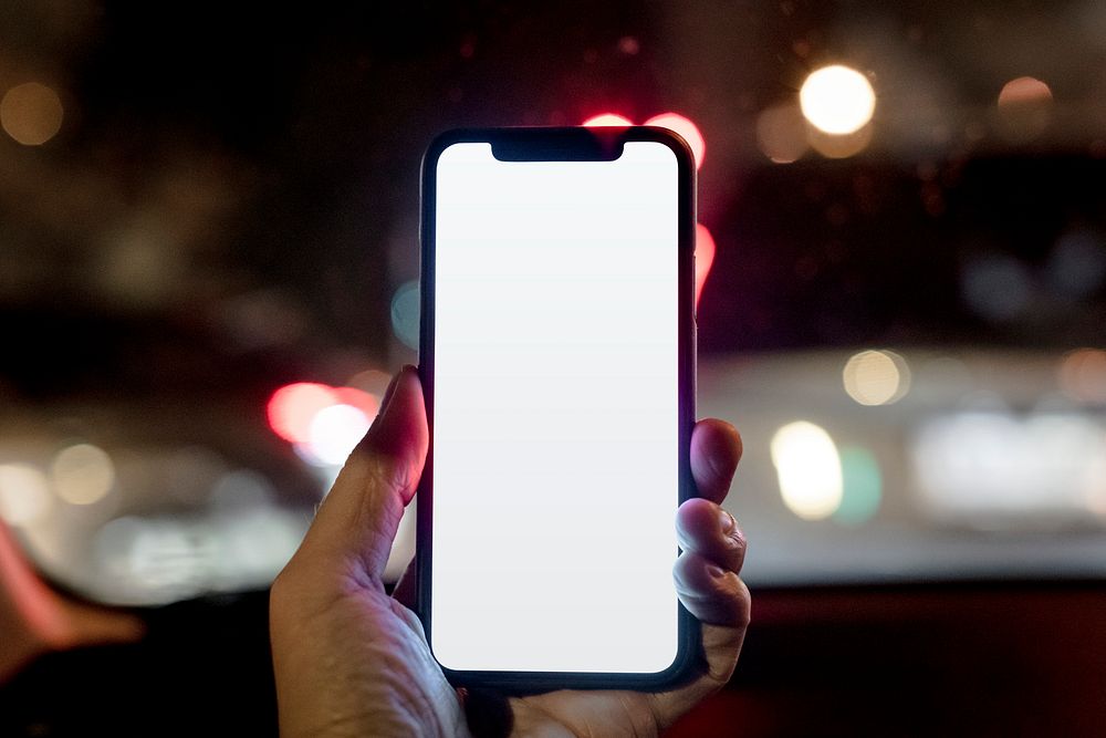 Guy holding a blank smartphone screen while walking in the city