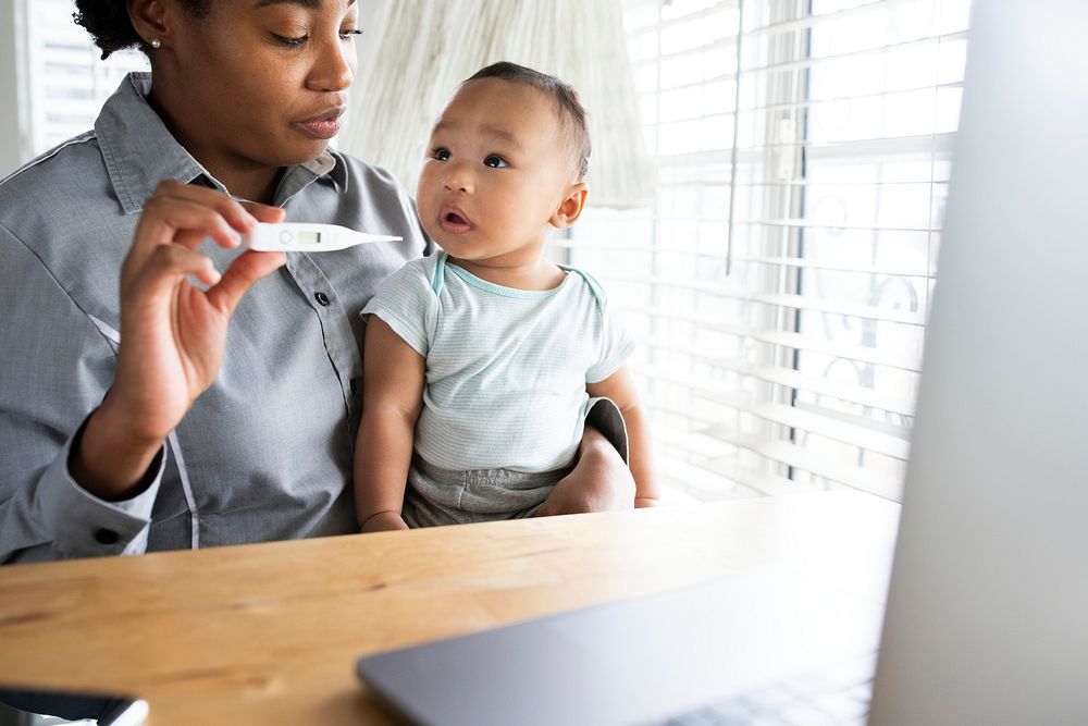Mother showing baby&rsquo;s fever to doctor through telemedicine call