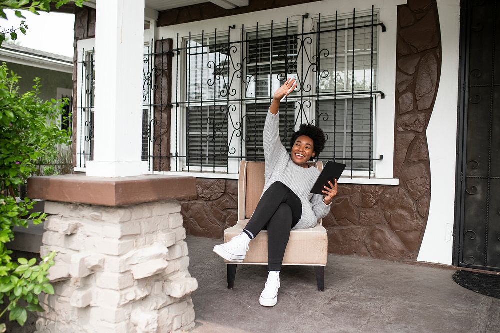 African American woman waving to a neighbor