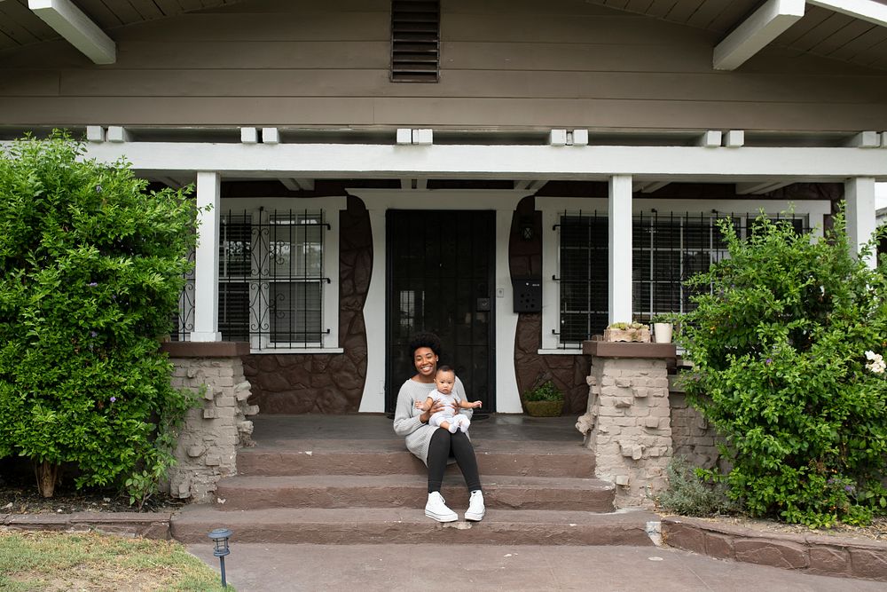 African American mother sitting with her son on the front porch