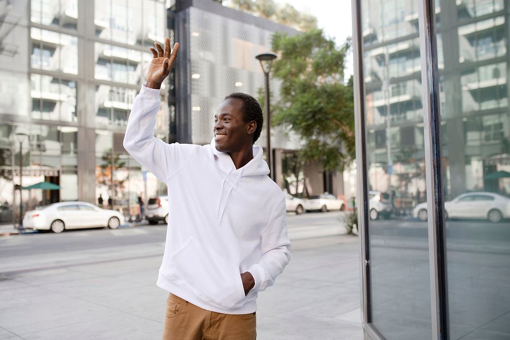 White hoodie on man with brown pants in the city