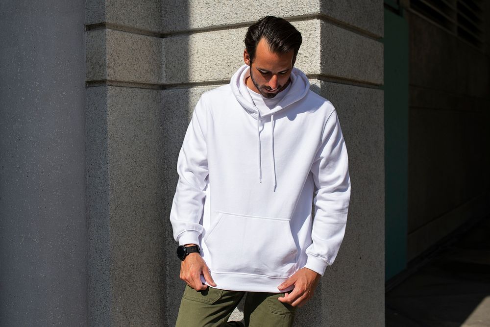 White hoodie on man with green pants in the city
