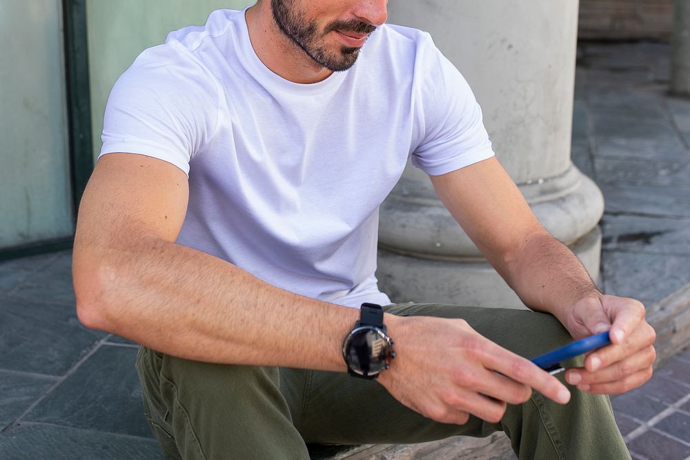 Casual white tee mockup psd  on man using the phone outdoor photoshoot