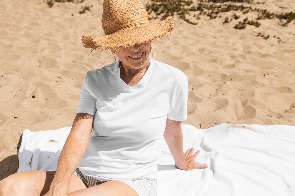 Senior woman in sun hat chilling at the beach
