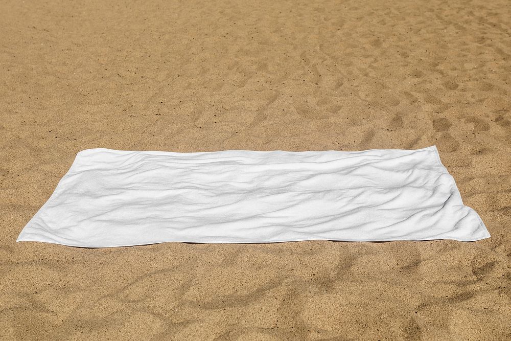 White beach towel psd mockup laying on the sand