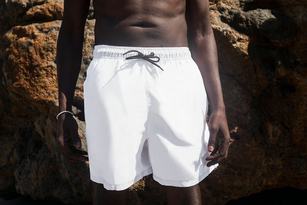 African American man in white swim shorts at the beach