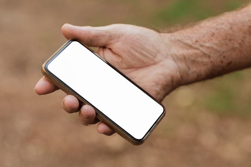 Senior man holding smartphone with white screen
