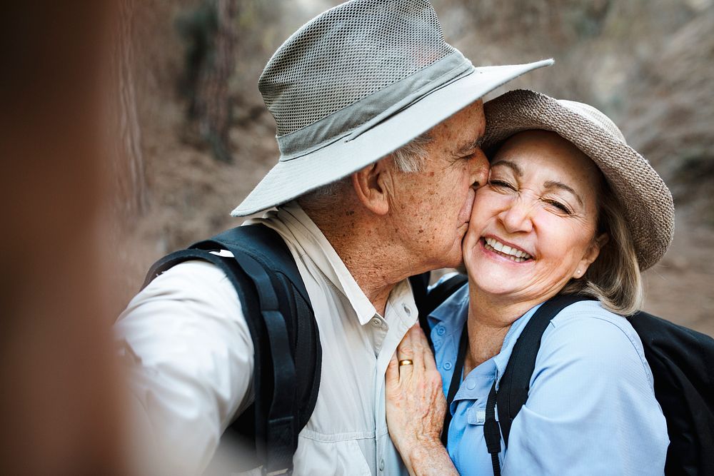 Happy senior partners taking selfie in the forest 