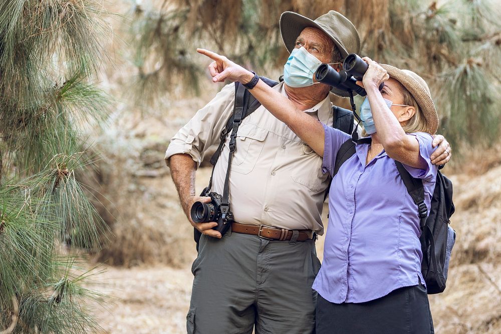 Couple appreciating the beauty of nature with binoculars during the new normal 