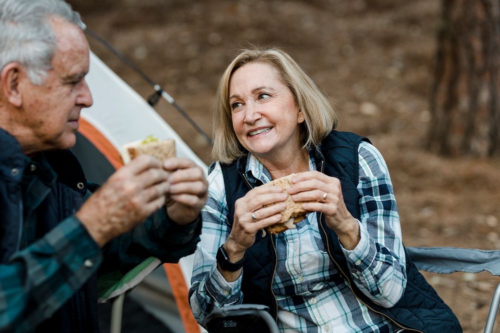 Romantic senior couple having a picnic by the campsite