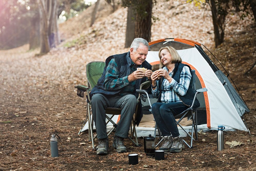 Romantic senior couple having a picnic by the campsite
