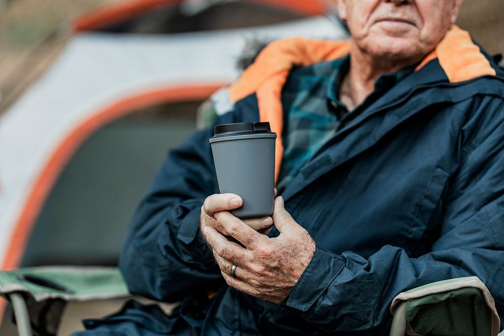 Senior man holding gray reusable travel cup