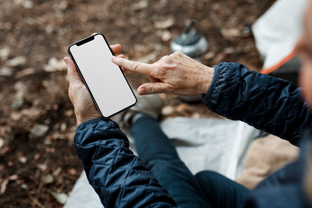 Smartphone white screen mockup psd with senior woman holding it