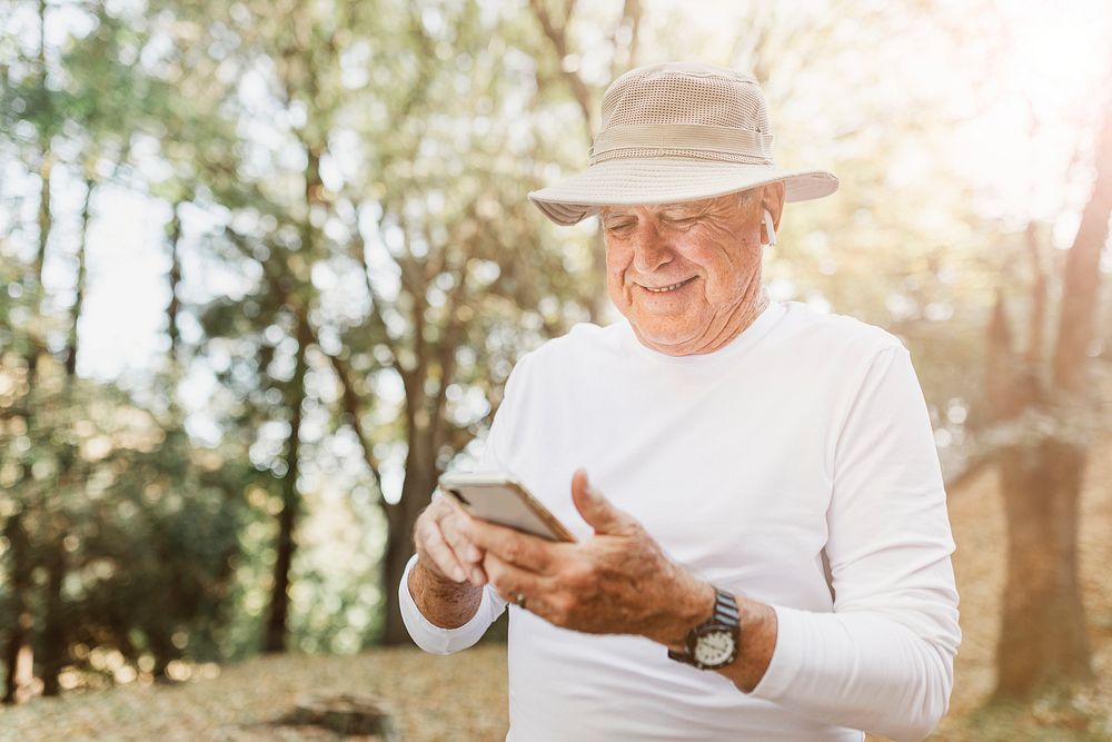 Modern grandpa enjoying his digital gadgets in nature