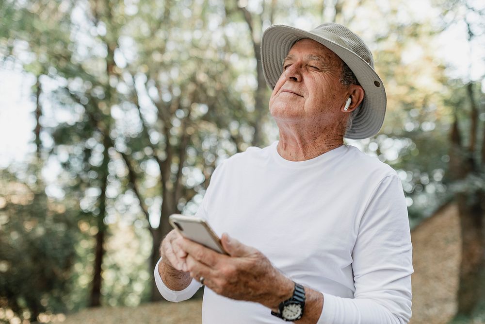 Modern grandpa enjoying his digital gadgets in nature