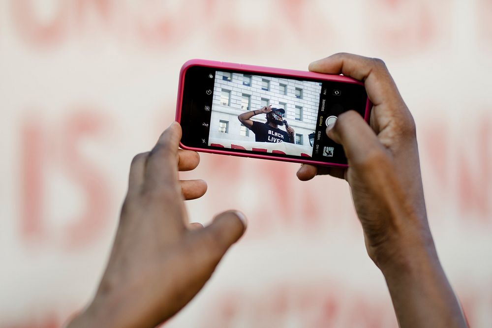 Black using an iPhone at a Black Lives Matter protest outside the Hall of Justice in Downtown Los Angeles. 15 JUL, 2020 -…