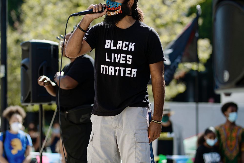 Man on a stage giving a speech at a Black Lives Matter protest outside the Hall of Justice in Downtown Los Angeles. 15 JUL…