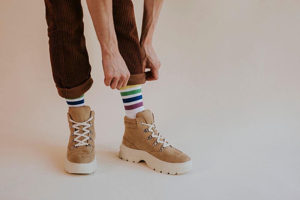 Model folding up pant leg with hiking boot