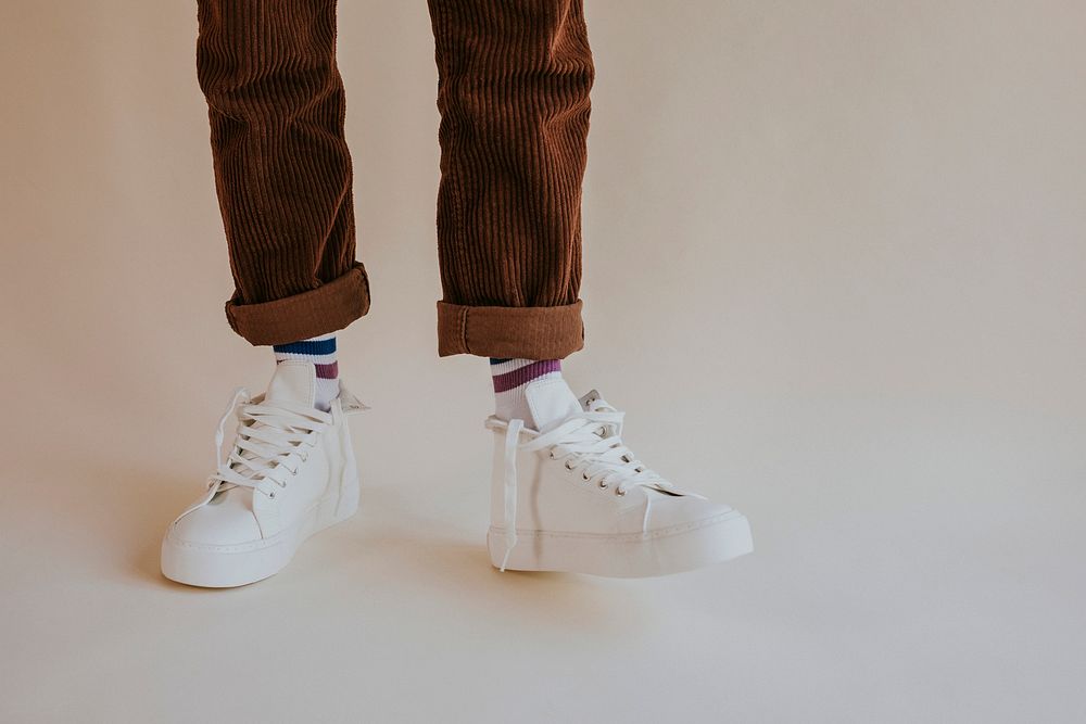 Model wearing white sneakers with untied shoelaces