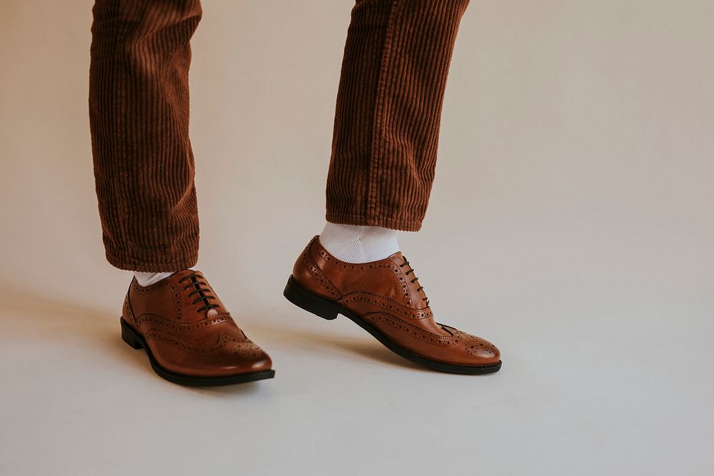 Men's leg in brown leather shoes