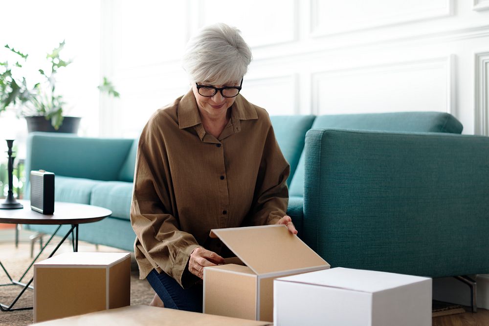 Woman unpacking brown boxes in the living room