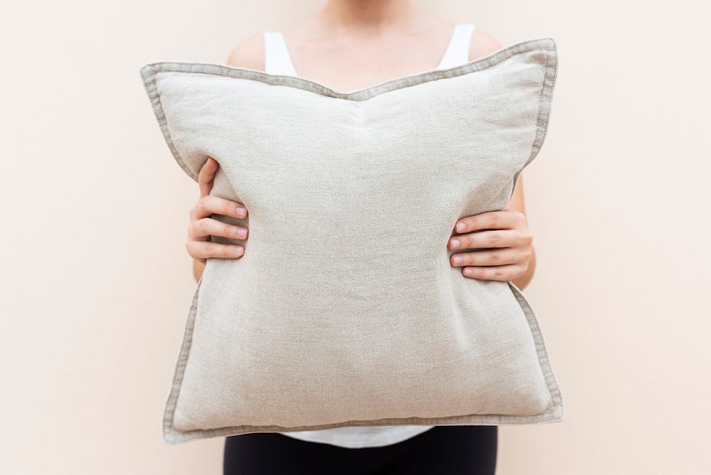 Woman holding a beige cushion