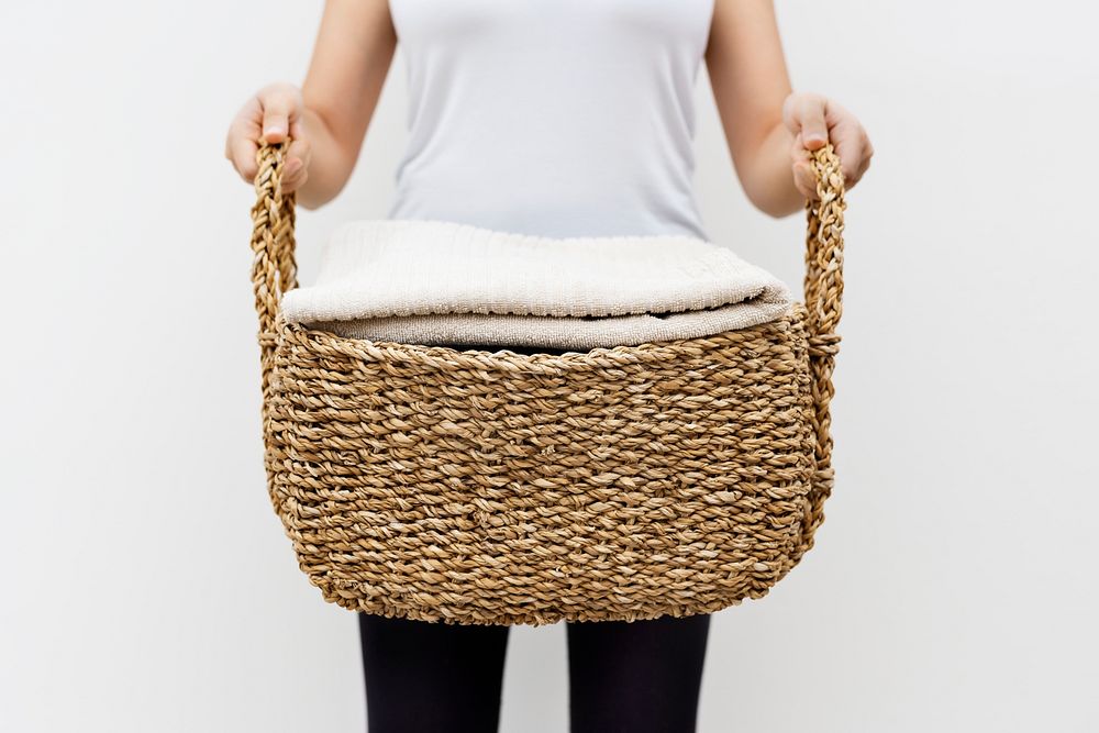 Woman carrying weaved laundry basket lifestyle concept