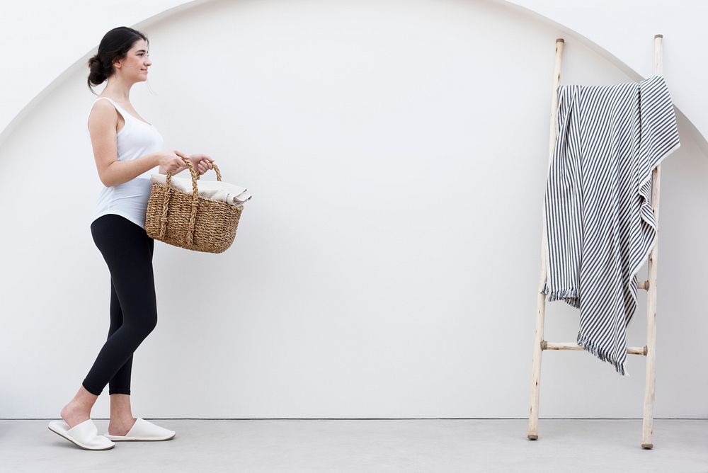 Woman carrying weaved laundry basket lifestyle concept