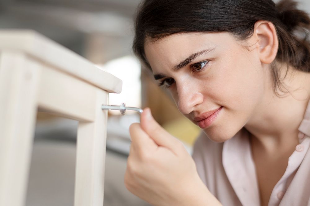Woman screwing in chair&rsquo;s nail for ready-to-assemble furniture