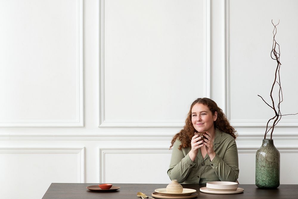 Happy woman enjoying tea at the dining table
