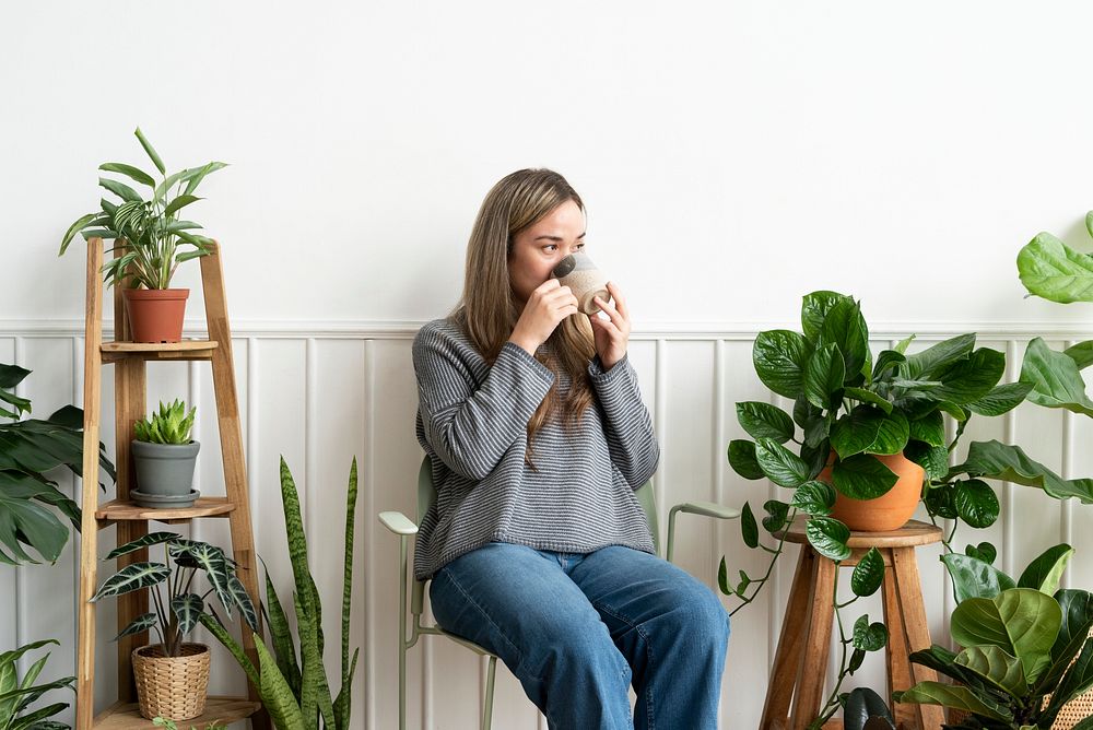 Plant lady resting and sipping tea in her plant corner
