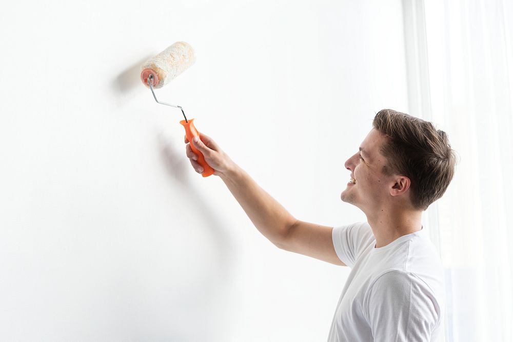 Man painting his wall white 