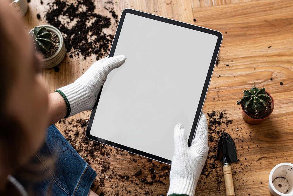 Digital tablet with empty screen on a hand of a gardener