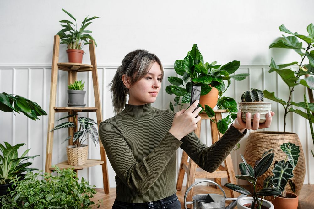 Woman taking a snapshot of her plant for social media 