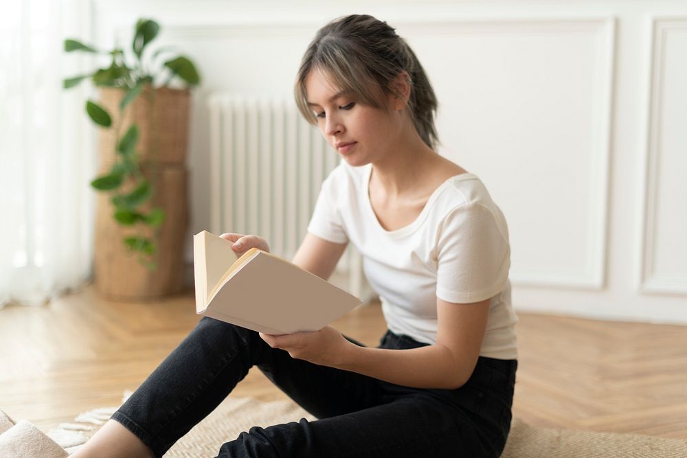 Woman reading a book sitting on a floor