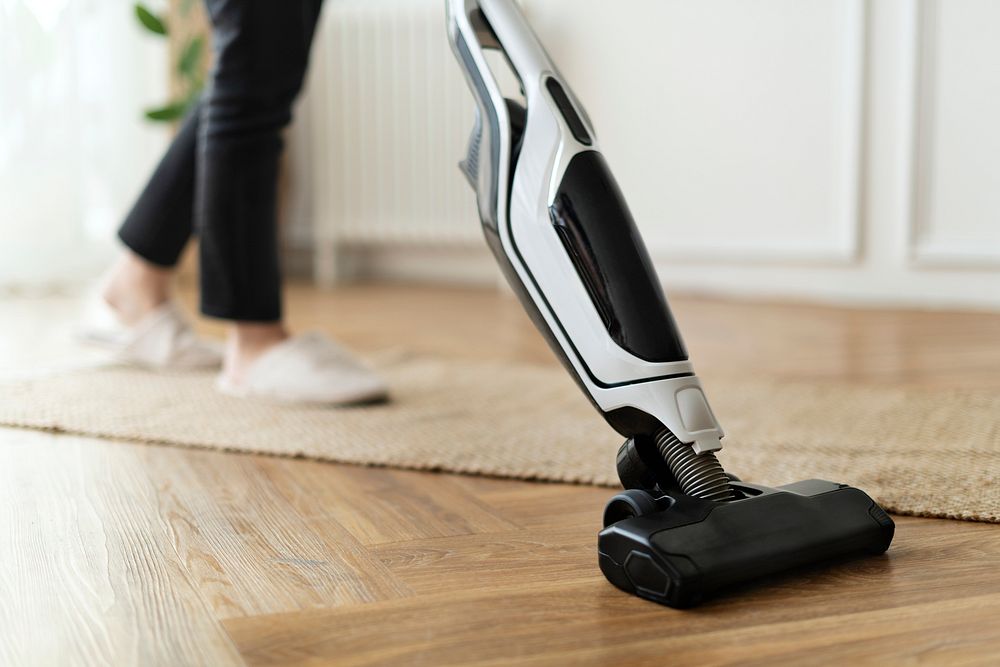 Housewife vacuuming a parquet floor