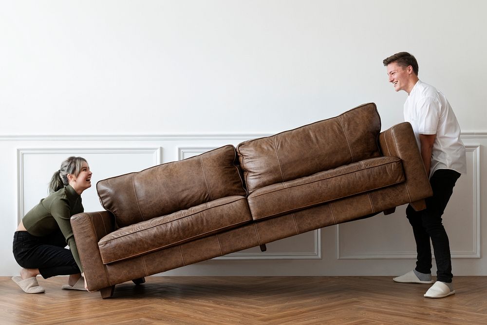 Couple moving a sofa in a new home