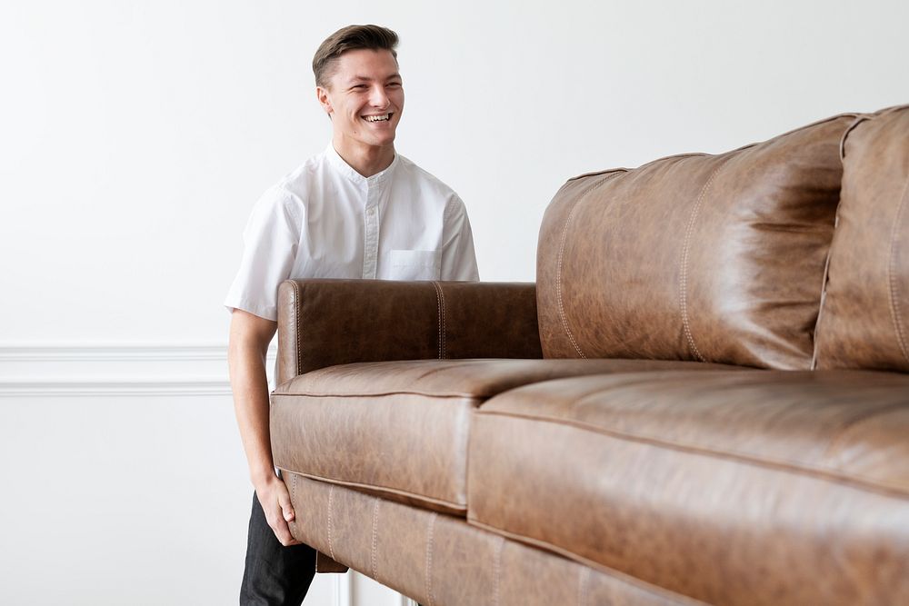 Man moving a sofa in a new home