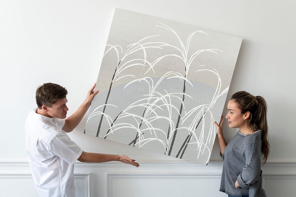 Japanese print on a canvas being hung by a couple